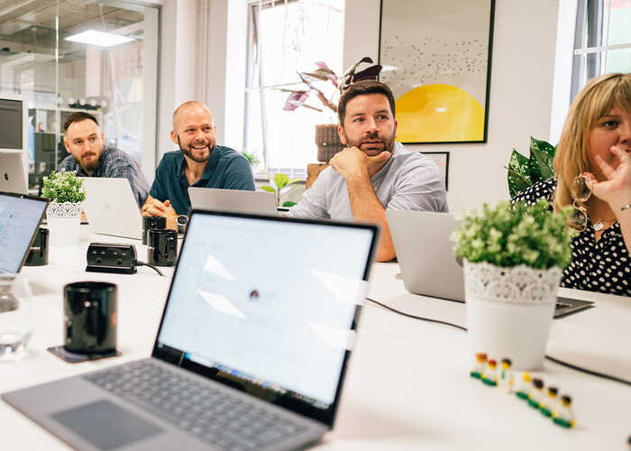 Sonder team members working in the office over a laptop